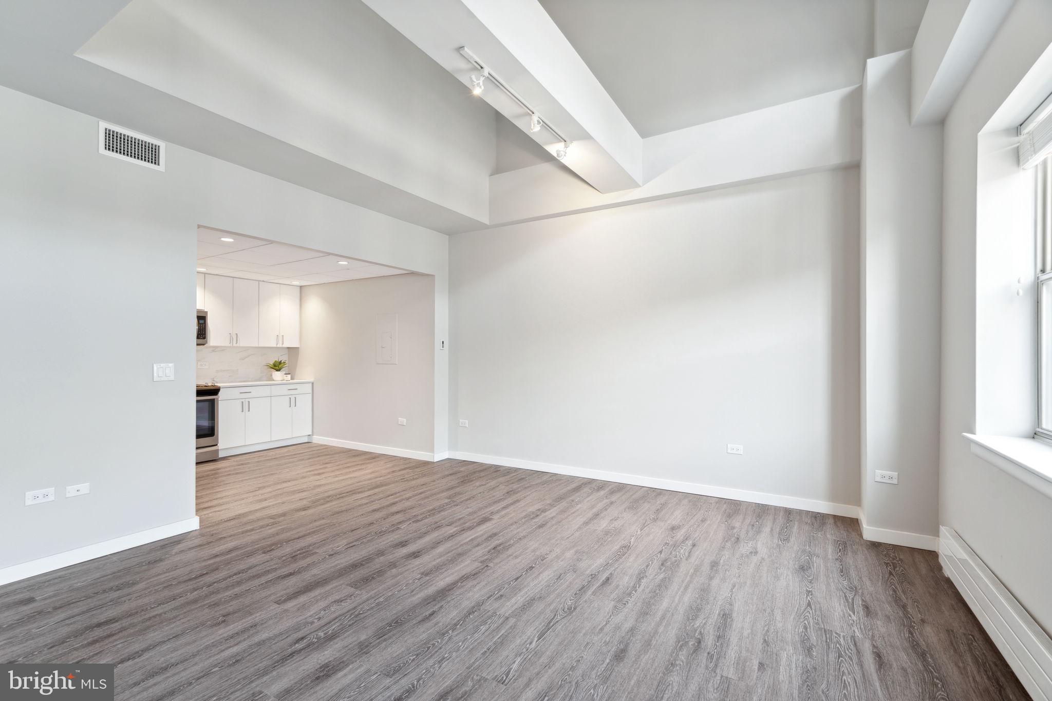 101-111 South 9th Street, Unit PH107 Philadelphia, PA 19107 - Photo 5 of 42 a view of an empty room with wooden floor and a window