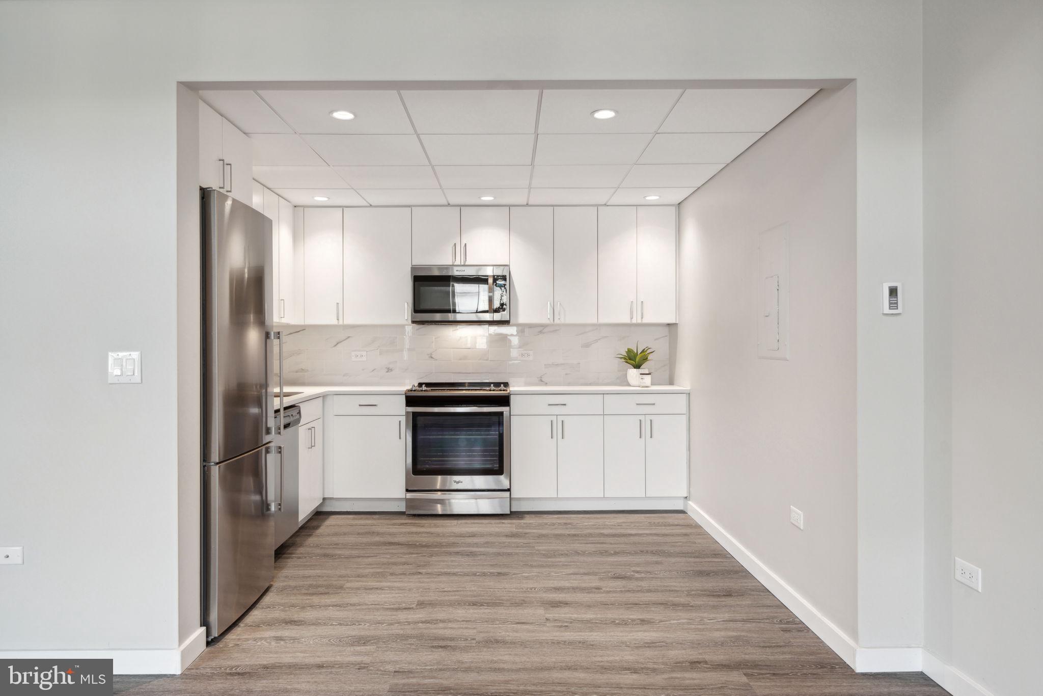 101-111 South 9th Street, Unit PH107 Philadelphia, PA 19107 - Photo 9 of 42 a kitchen with stainless steel appliances a refrigerator and a stove top oven
