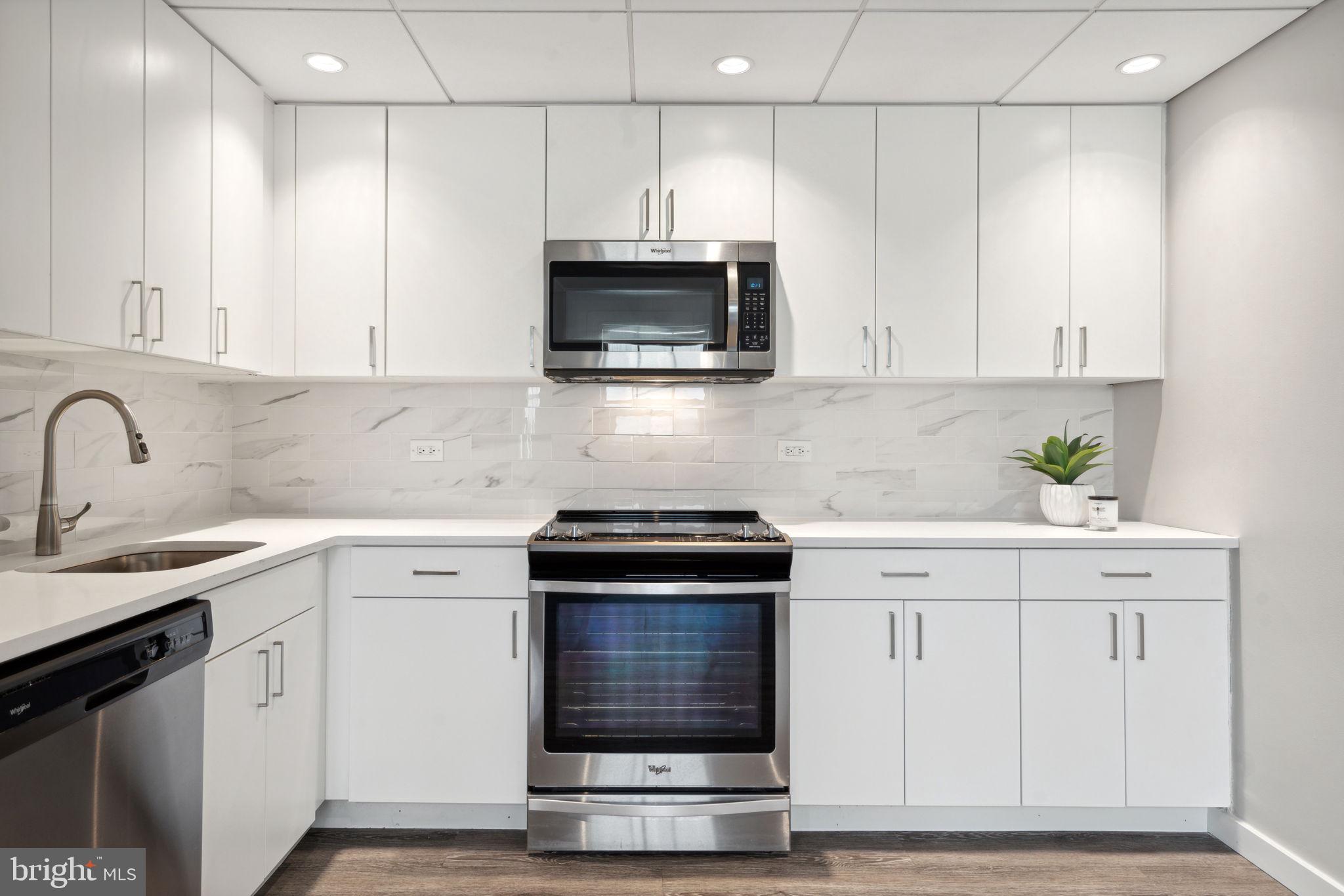 101-111 South 9th Street, Unit PH107 Philadelphia, PA 19107 - Photo 10 of 42 a kitchen with granite countertop white cabinets and stainless steel appliances