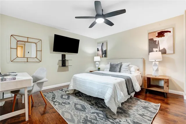 a bedroom with a bed a flat screen tv and a dresser