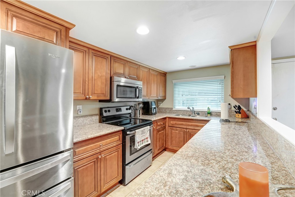 6882 Alondra Boulevard, Unit 26 Paramount, CA 90723 - Photo 4 of 14 a kitchen with stainless steel appliances granite countertop a refrigerator a stove top oven a sink and dishwasher
