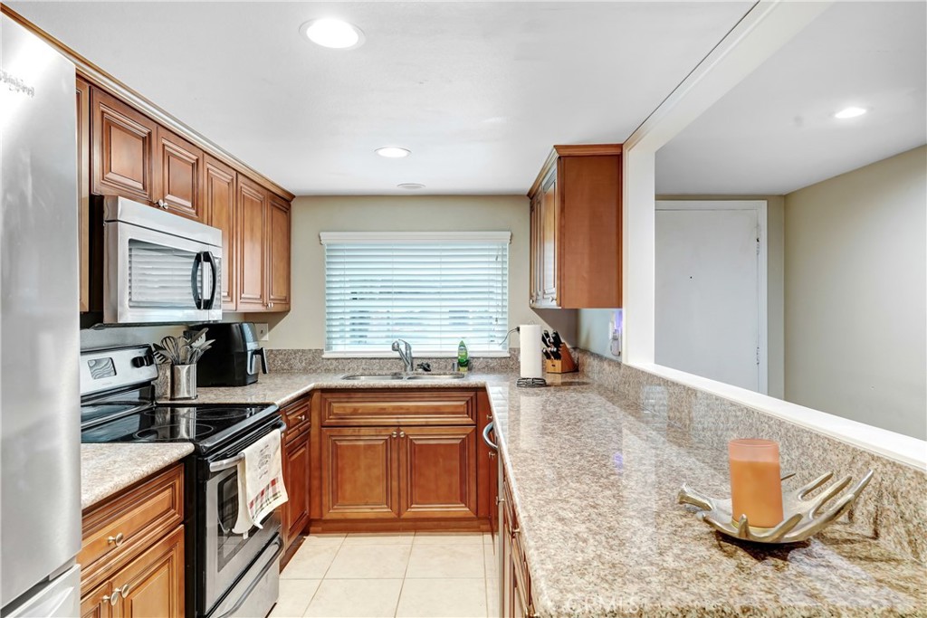 6882 Alondra Boulevard, Unit 26 Paramount, CA 90723 - Photo 5 of 14 a kitchen with stainless steel appliances granite countertop a sink stove and cabinets