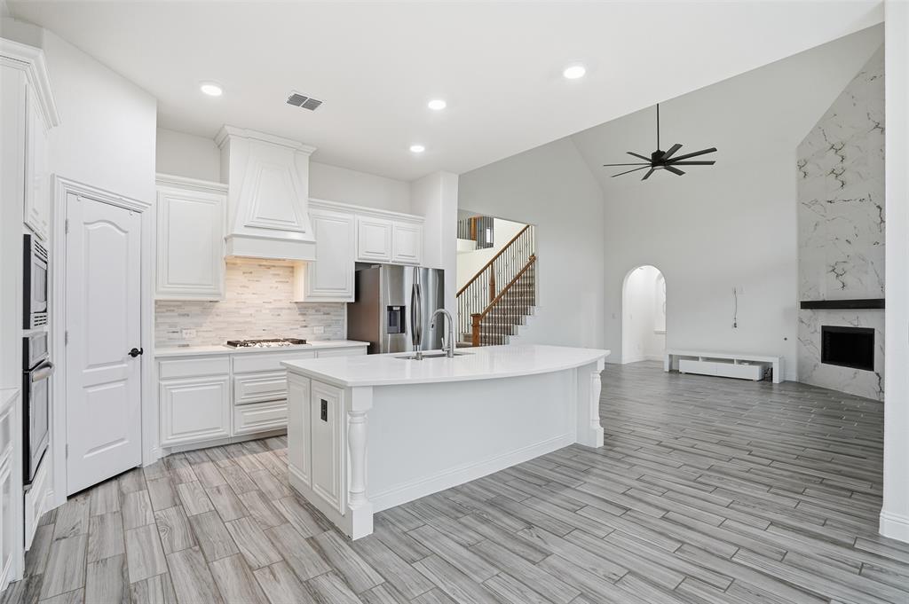 2604 Dylan Lane Mansfield, TX 76063 - Photo 11 of 33 a kitchen with stainless steel appliances a refrigerator a sink dishwasher a stove and white cabinets with wooden floor