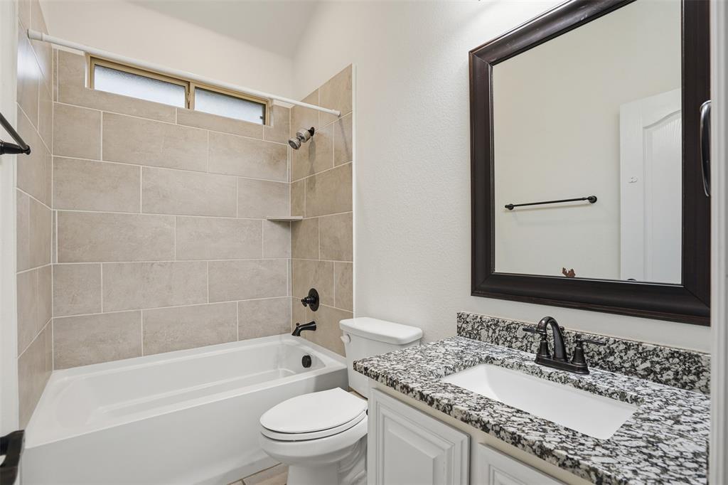 2604 Dylan Lane Mansfield, TX 76063 - Photo 21 of 33 a bathroom with a granite countertop sink toilet mirror and shower
