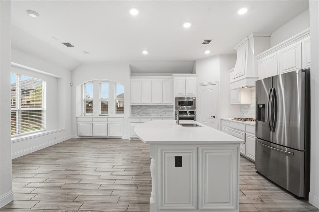2604 Dylan Lane Mansfield, TX 76063 - Photo 9 of 33 a kitchen with kitchen island a refrigerator sink and cabinets