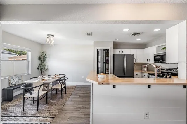 a kitchen with stainless steel appliances kitchen island granite countertop a refrigerator and cabinets