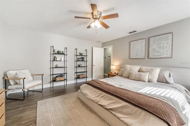 a spacious bedroom with a bed a couch and a bookshelf