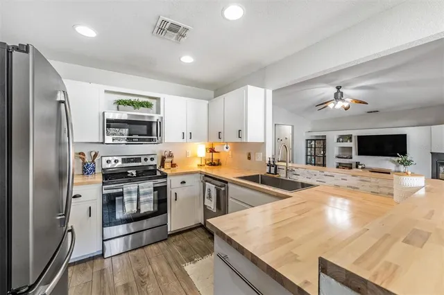 a kitchen with stainless steel appliances granite countertop a sink stove microwave and refrigerator