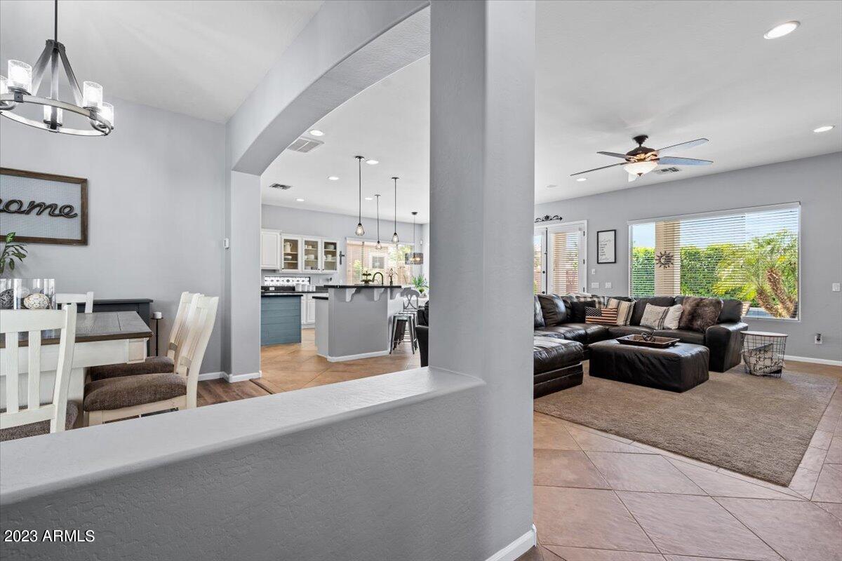 6730 Rachael Way Gilbert, AZ 85298 - Photo 12 of 77 a living room with furniture a chandelier and a view of kitchen