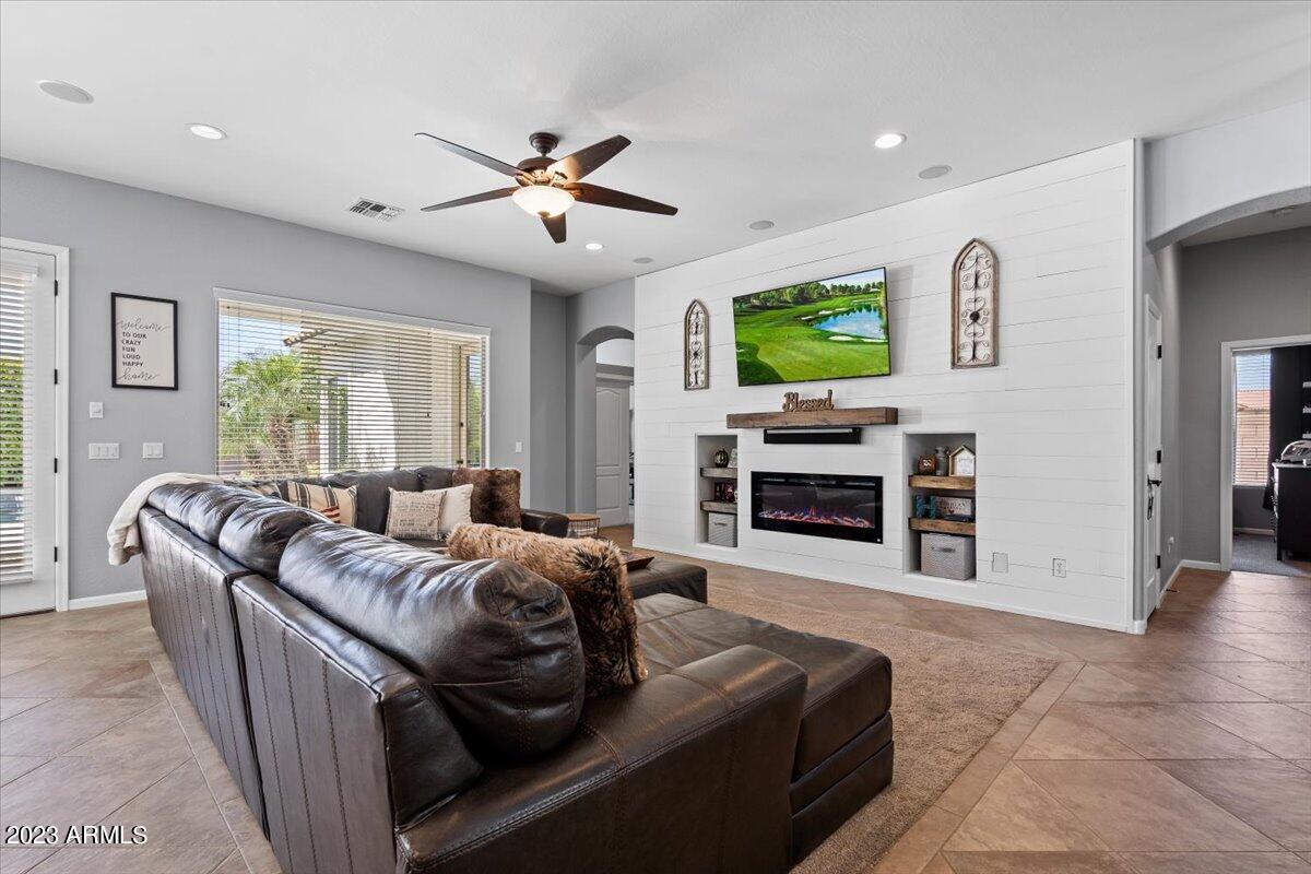 6730 Rachael Way Gilbert, AZ 85298 - Photo 15 of 77 a living room with furniture a flat screen tv and a fireplace