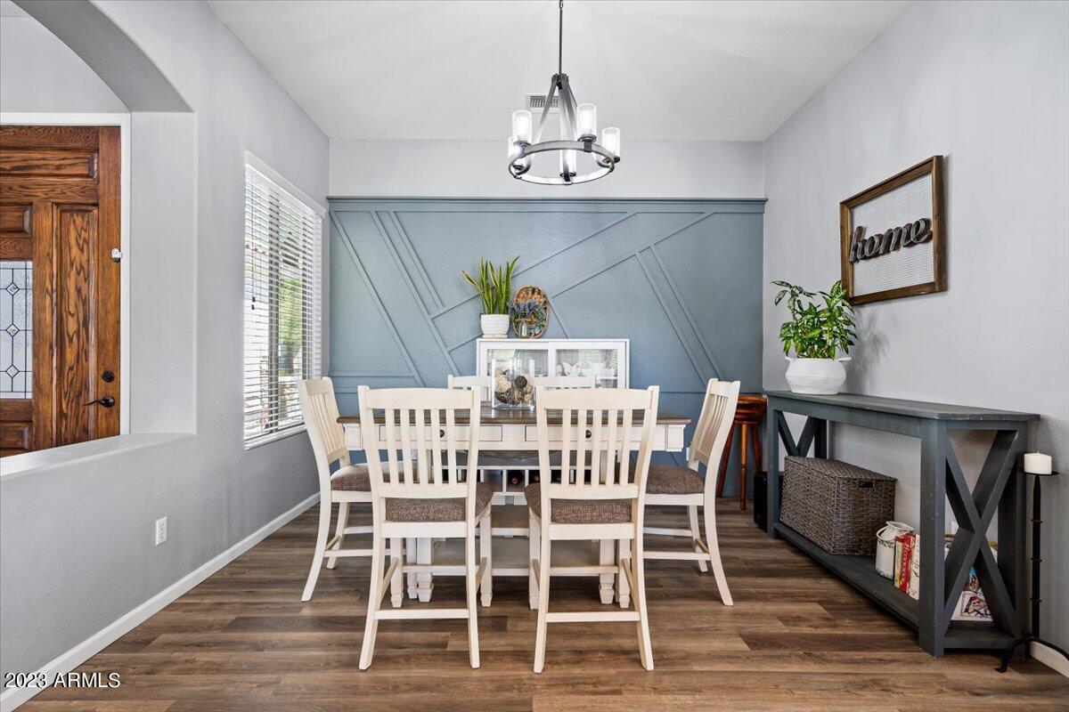 6730 Rachael Way Gilbert, AZ 85298 - Photo 19 of 77 a view of a dining room with furniture wooden floor and a chandelier