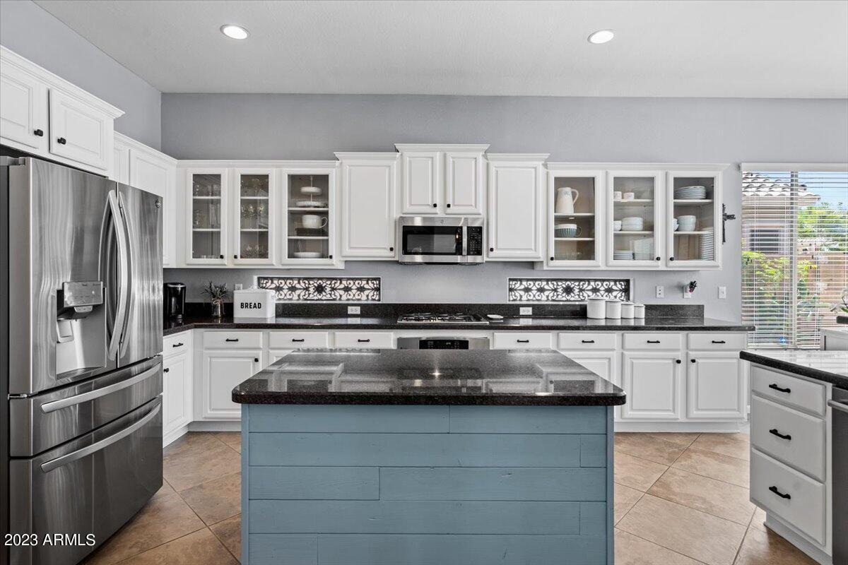 6730 Rachael Way Gilbert, AZ 85298 - Photo 21 of 77 a kitchen with granite countertop a refrigerator stove and microwave