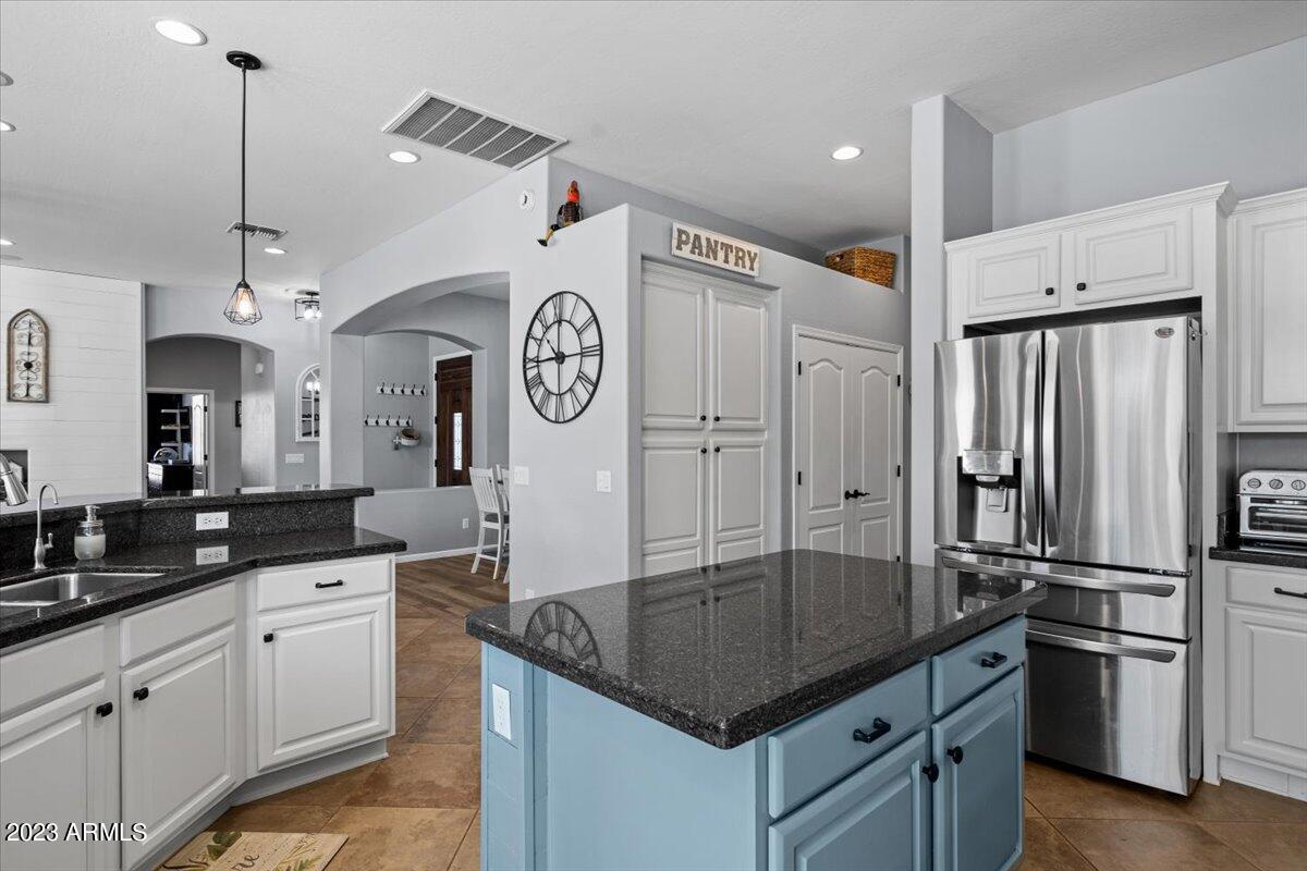 6730 Rachael Way Gilbert, AZ 85298 - Photo 23 of 77 a kitchen with stainless steel appliances granite countertop a sink a refrigerator and a view of living room