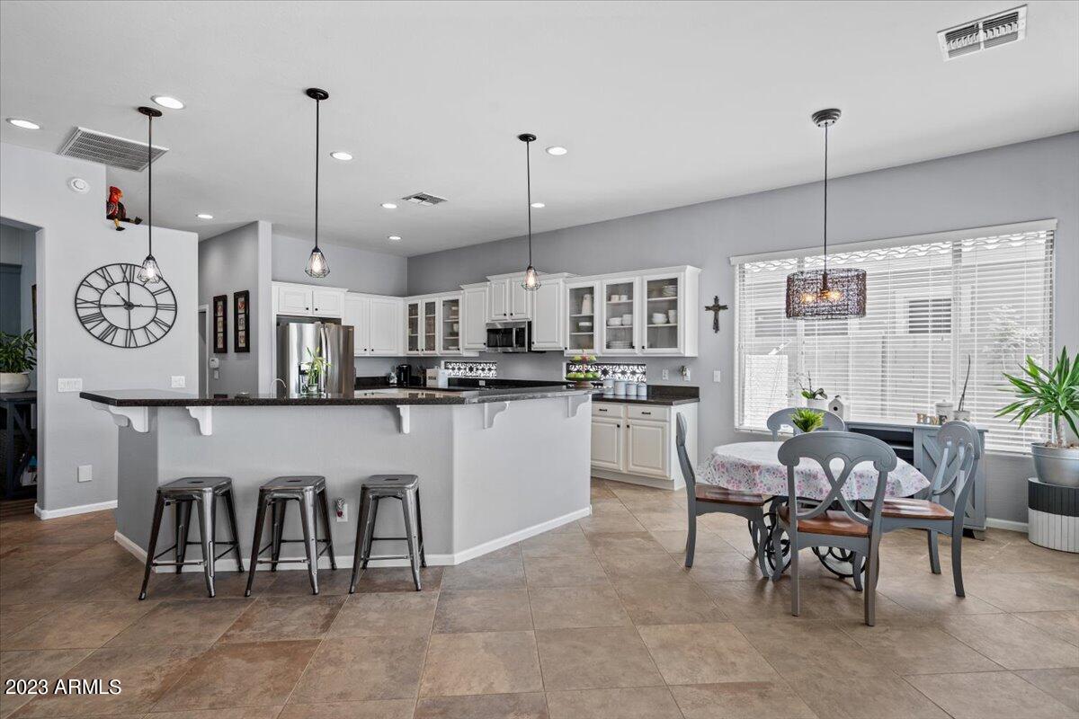 6730 Rachael Way Gilbert, AZ 85298 - Photo 26 of 77 a room with stainless steel appliances kitchen island granite countertop furniture and a dining table