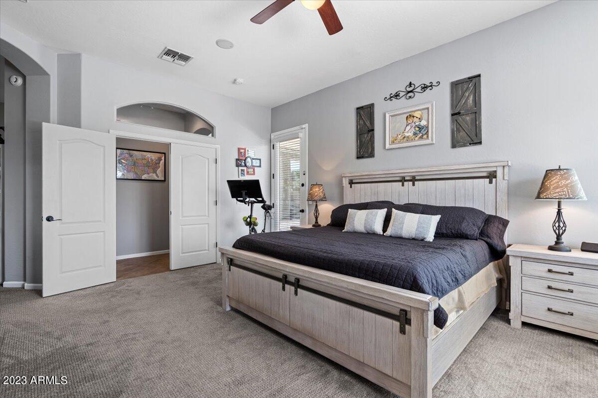 6730 Rachael Way Gilbert, AZ 85298 - Photo 30 of 77 a spacious bedroom with a bed and a chandelier