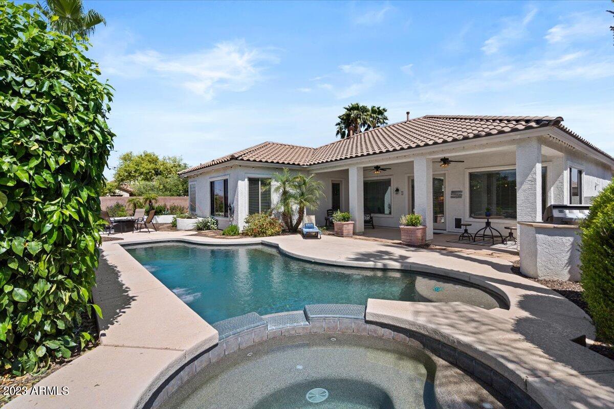 6730 Rachael Way Gilbert, AZ 85298 - Photo 52 of 77 a view of a house with swimming pool and a dining table and chairs under an umbrella
