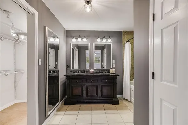 a bathroom with a granite countertop sink a mirror and a shower
