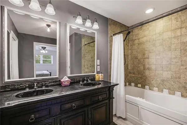 a bathroom with a bathtub sink and mirror