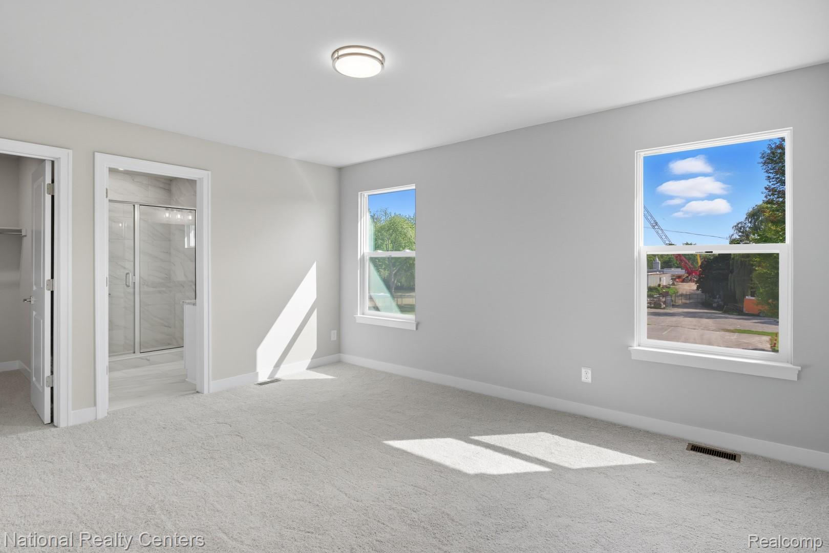25018 Reeck Road Trenton, MI 48183 - Photo 30 of 32 Neutral wall paint, plush carpeting, two windows, ceiling-mounted light fixture, and an adjoining bathroom featuring a glass-enclosed shower