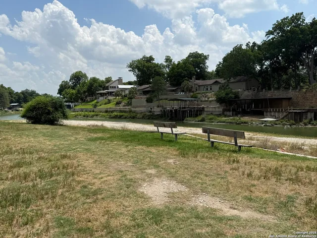 a view of a water pond with green yard