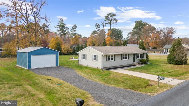 a view of a house with a yard and large tree