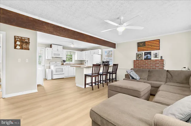 a living room with furniture and kitchen view