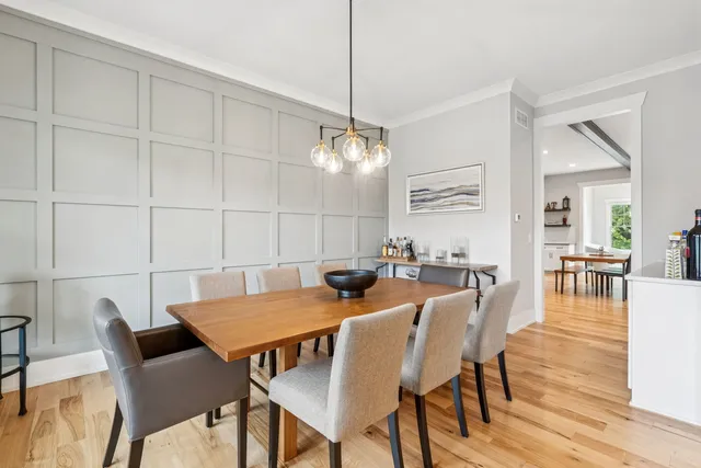 a view of a living room and a chandelier fan and wooden floor