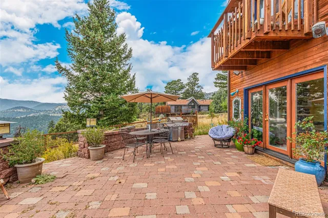 a view of a patio with table and chairs potted plants with wooden fence