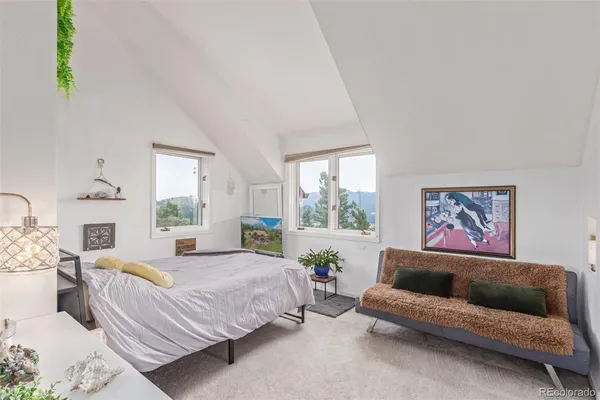 a spacious bedroom with a bed couch and window