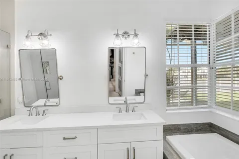 a bathroom with a tub sink and mirror