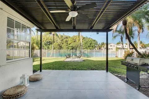 a porch with a table and chairs next to a yard