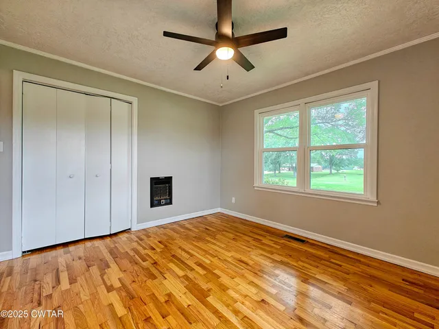 a view of empty room with window and ceiling fan