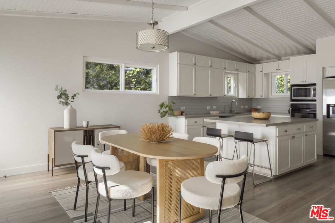 716 West Oak Avenue El Segundo, CA 90245 - Photo 11 of 35 a kitchen with stainless steel appliances kitchen island granite countertop a dining table chairs and a refrigerator