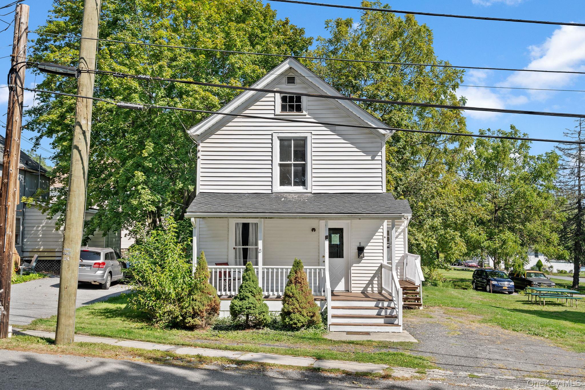 View of front of property featuring covered porch and a front yard
