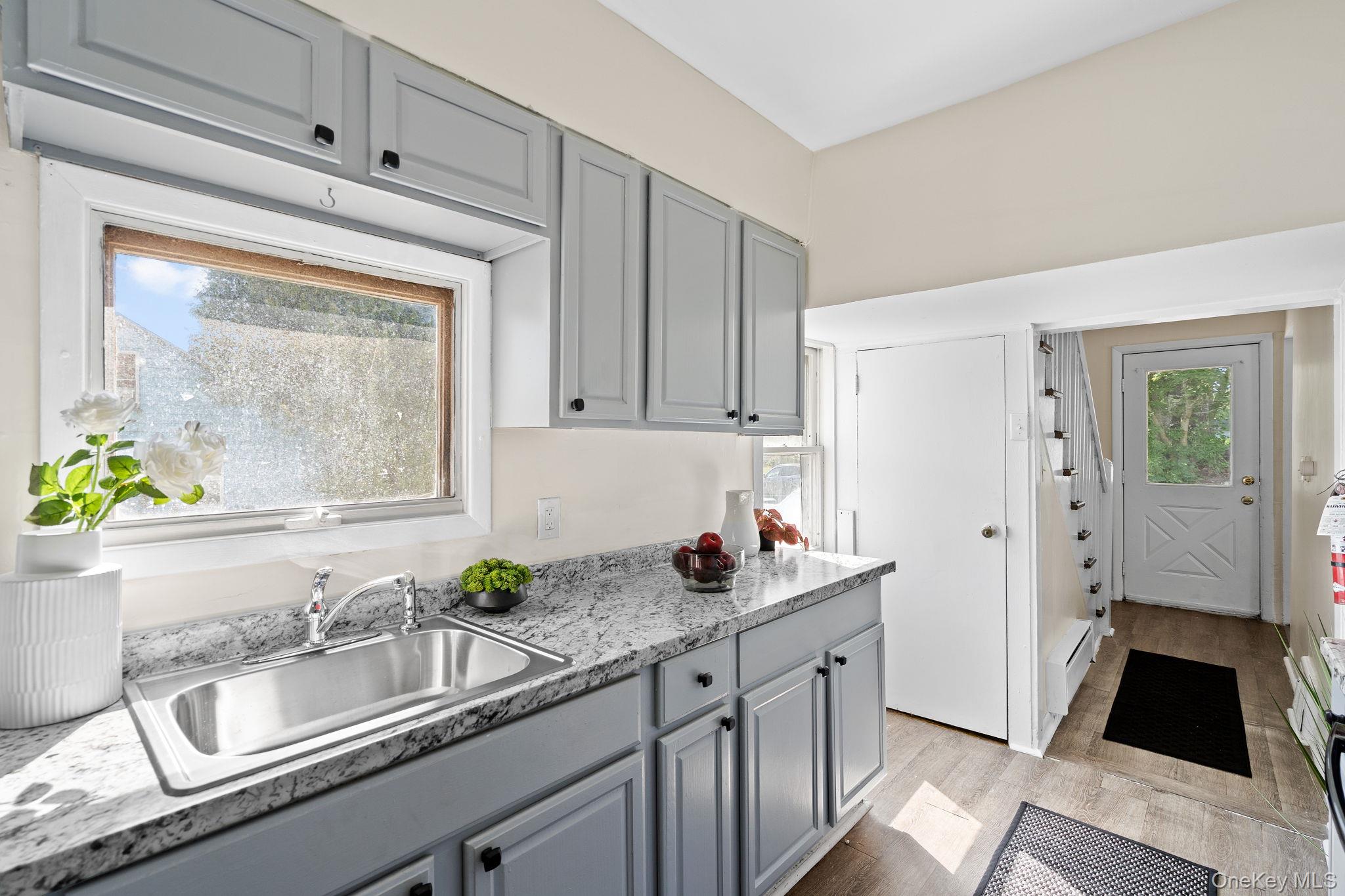 8 Coldenham Road Walden, NY 12586 - Photo 15 of 50 Kitchen with gray cabinets, light wood-style floors, baseboard heating, light stone countertops, and range