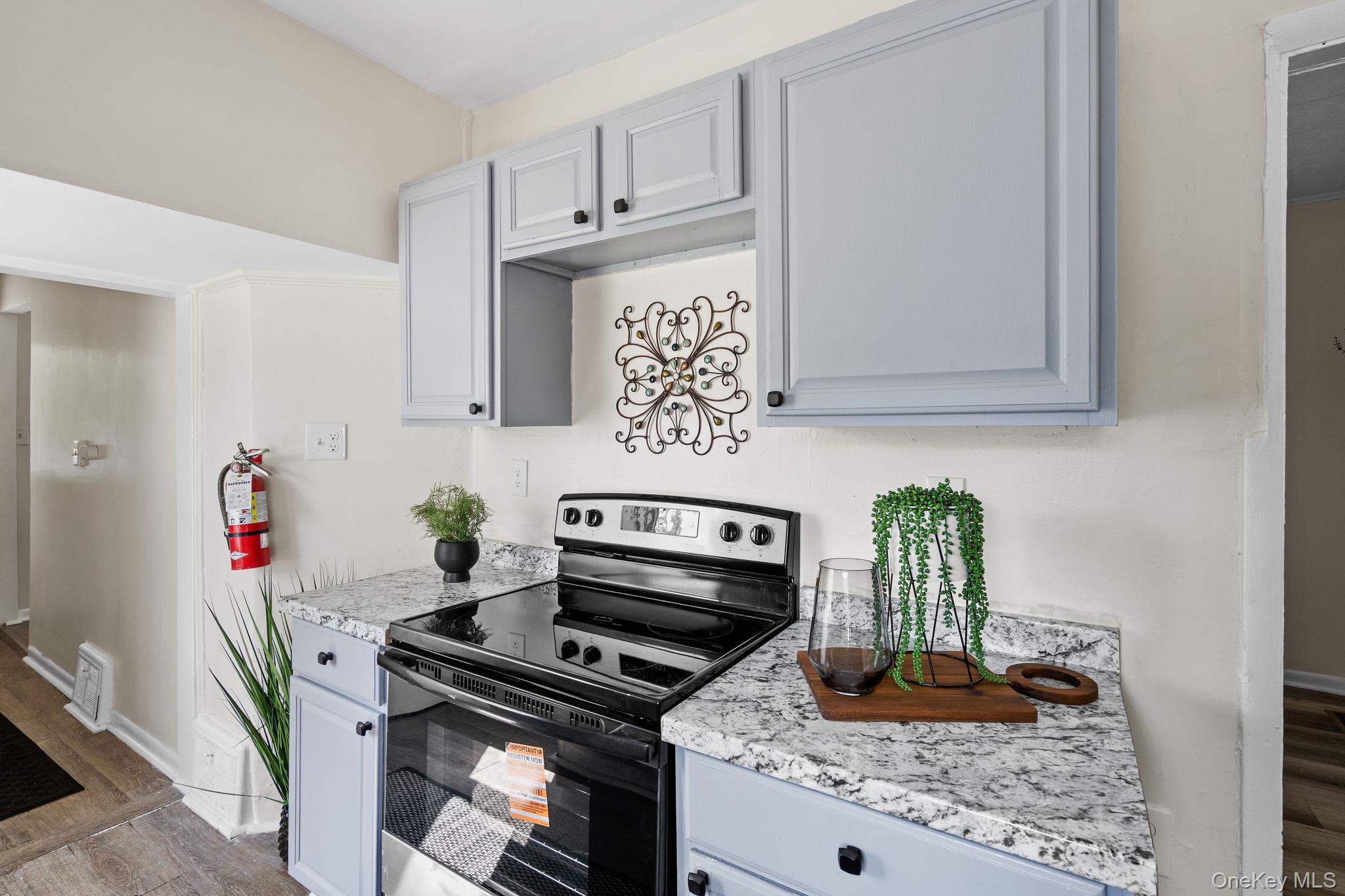 8 Coldenham Road Walden, NY 12586 - Photo 16 of 50 Kitchen featuring stainless steel range with electric cooktop, dark wood-style flooring, light stone counters, and gray cabinetry
