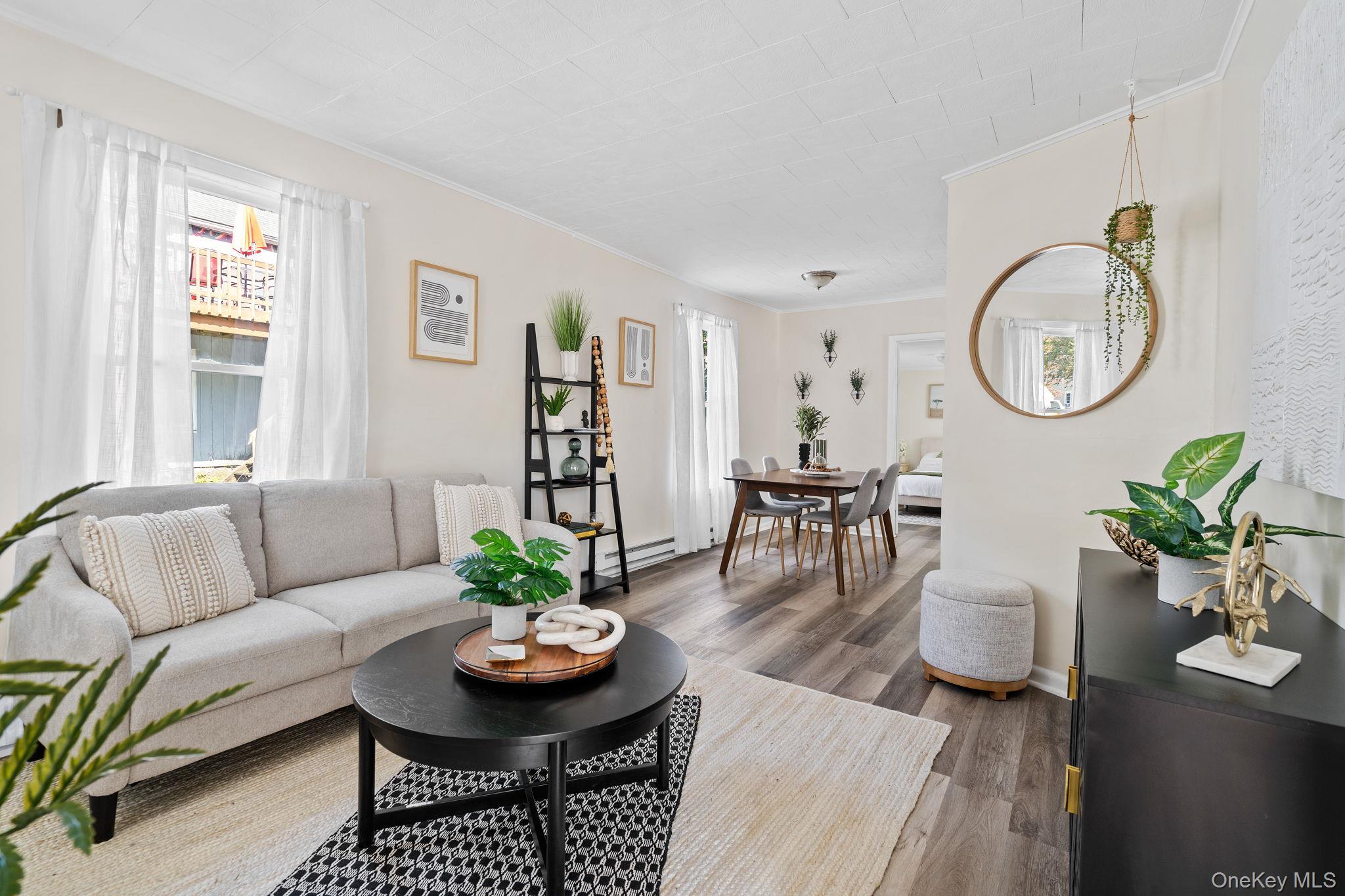 8 Coldenham Road Walden, NY 12586 - Photo 5 of 50 Living room featuring crown molding, healthy amount of natural light, wood finished floors, and a baseboard radiator