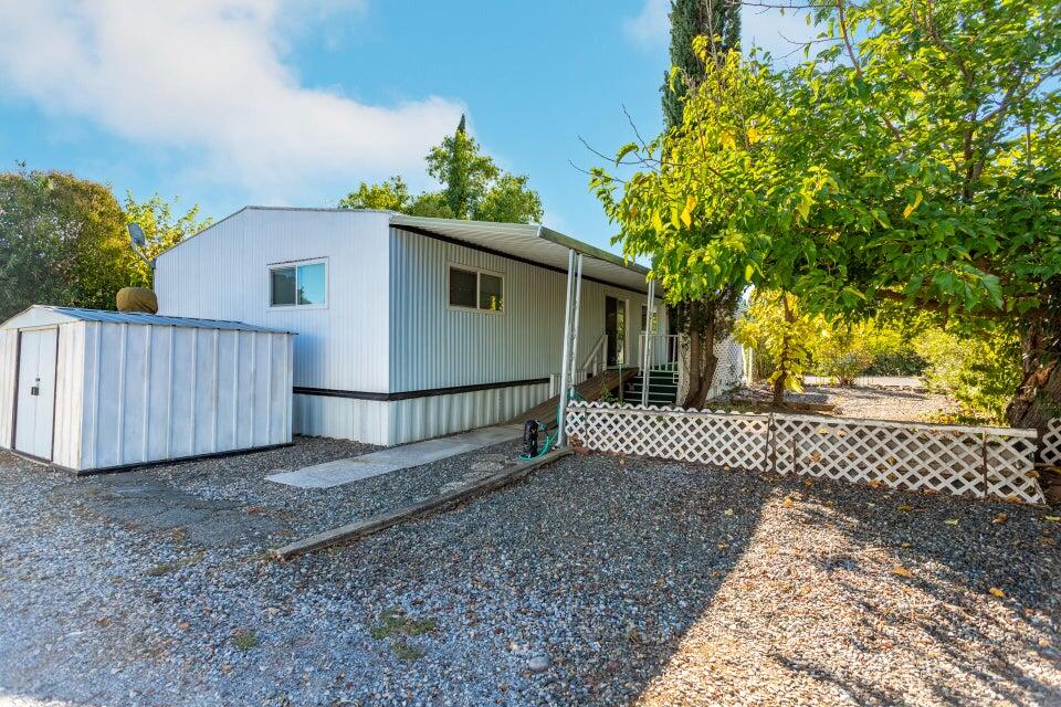 11037 Erickson Way, Unit 71 Redding, CA 96003 - Photo 13 of 13 a view of a house with a yard and wooden fence