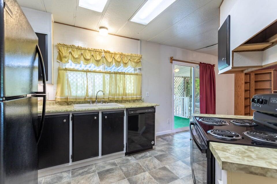 11037 Erickson Way, Unit 71 Redding, CA 96003 - Photo 7 of 13 a kitchen with stainless steel appliances granite countertop a stove a sink and a refrigerator