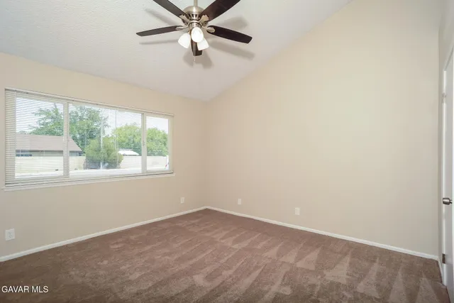 an empty room with a window and a fan