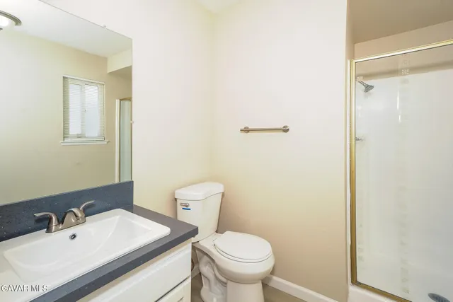a bathroom with a granite countertop sink mirror vanity and toilet