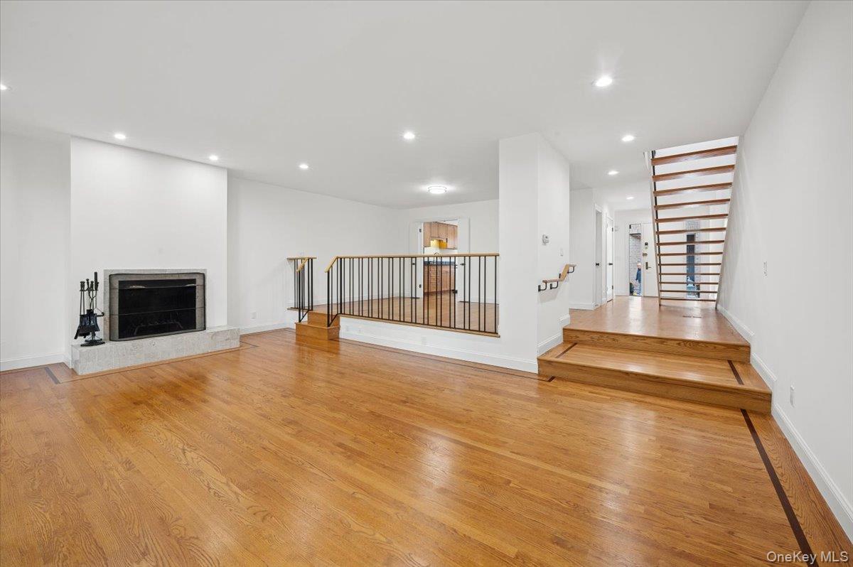 70 Waters Edge, Unit 70 Rye, NY 10580 - Photo 16 of 44 Unfurnished living room with light wood finished floors, a fireplace, recessed lighting, w/view of dining room and foyer and stairs