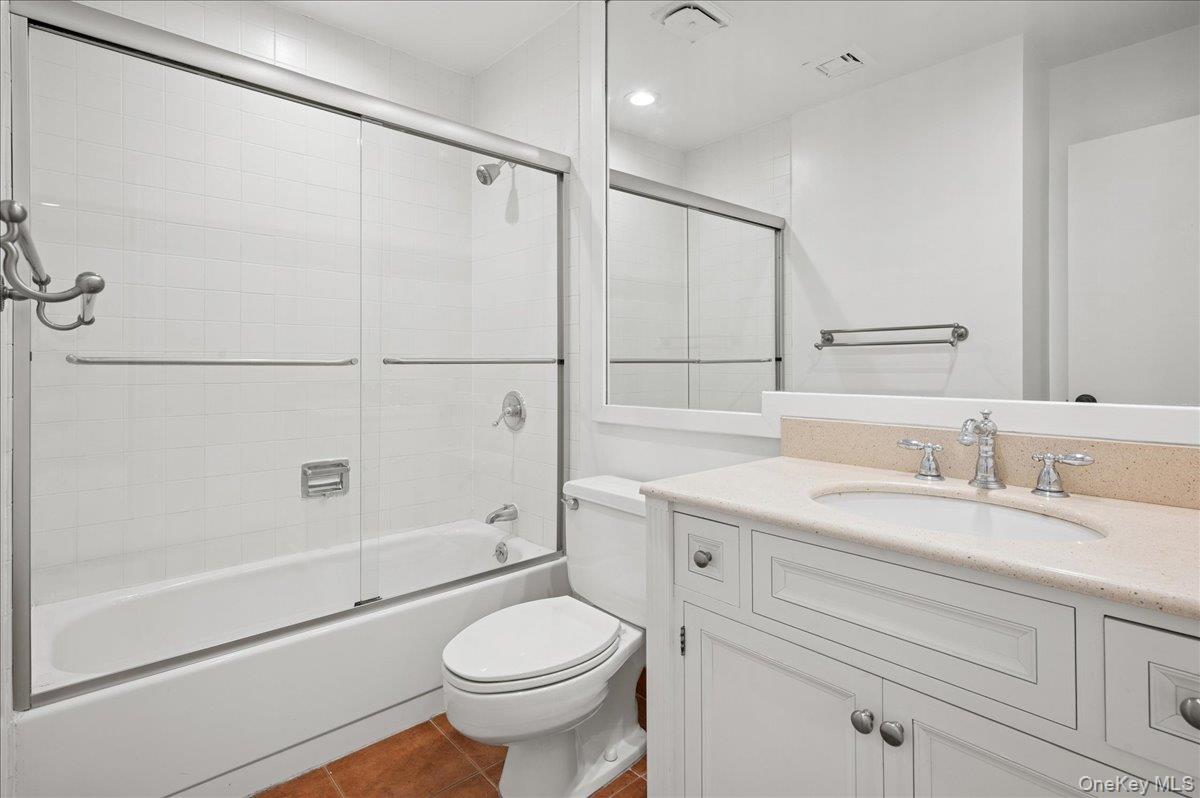 70 Waters Edge, Unit 70 Rye, NY 10580 - Photo 31 of 44 Full hall bathroom featuring dark tile patterned flooring, shower / bath combination with glass door, and vanity