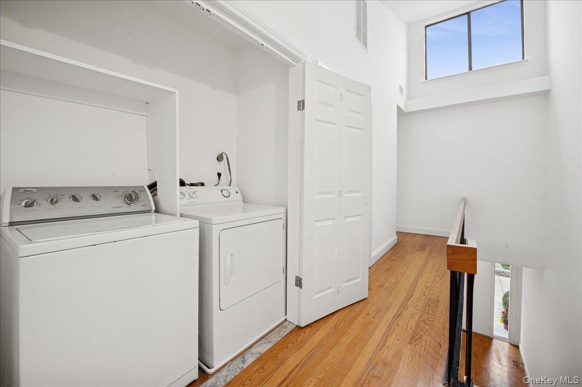 70 Waters Edge, Unit 70 Rye, NY 10580 - Photo 36 of 44 Laundry area in upstairs hallway with plenty of natural light, light wood finished floors, and washer and clothes dryer