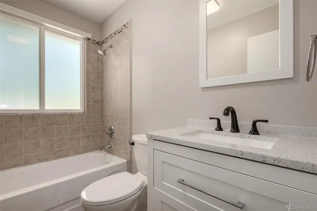 a bathroom with a granite countertop sink toilet and shower