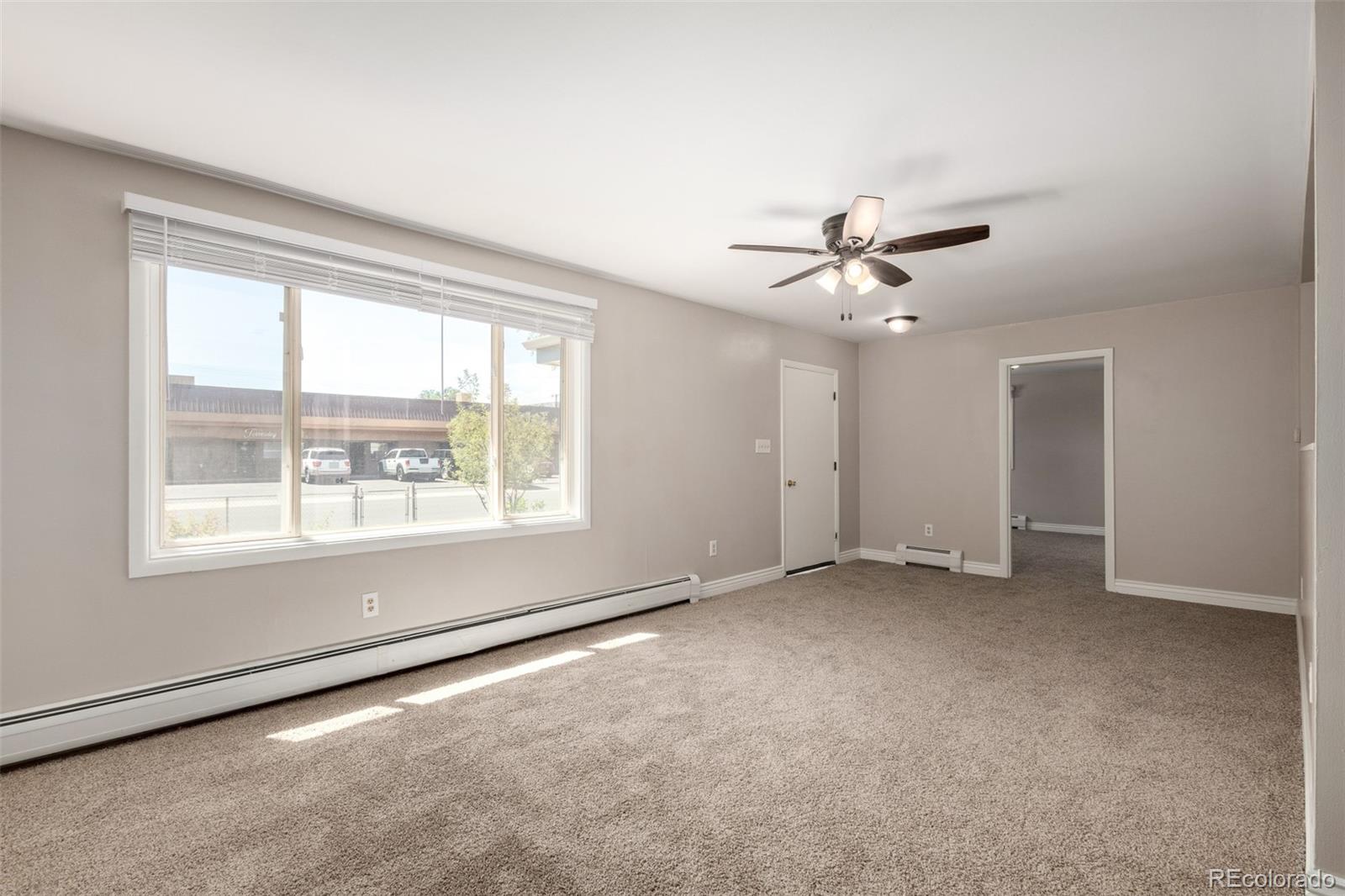 117 6th Street Frederick, CO 80530 - Photo 6 of 43 an empty room with a ceiling fan and window