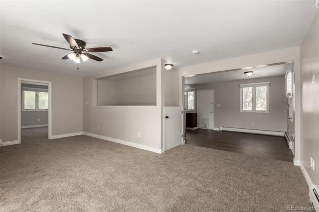 a view of a livingroom with a chandelier fan and windows