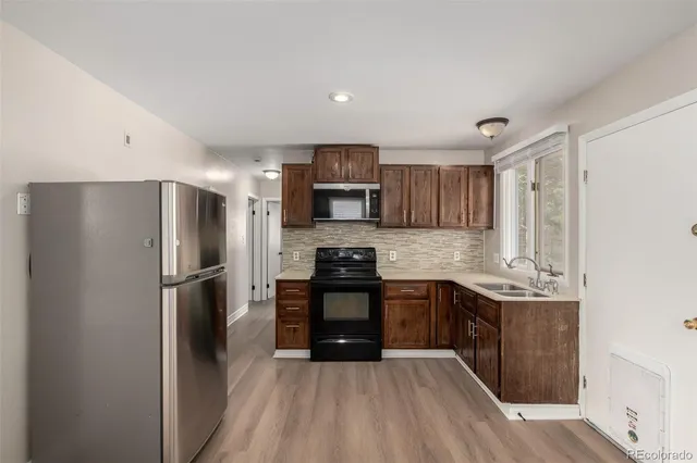 a kitchen with stainless steel appliances granite countertop a refrigerator stove and sink