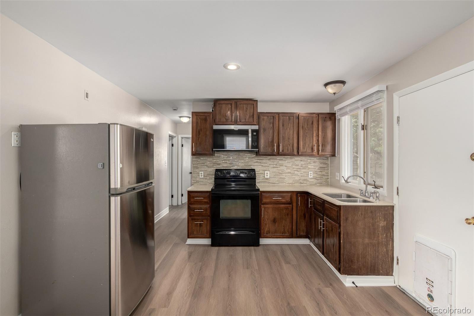 117 6th Street Frederick, CO 80530 - Photo 8 of 43 a kitchen with stainless steel appliances granite countertop a refrigerator stove and sink