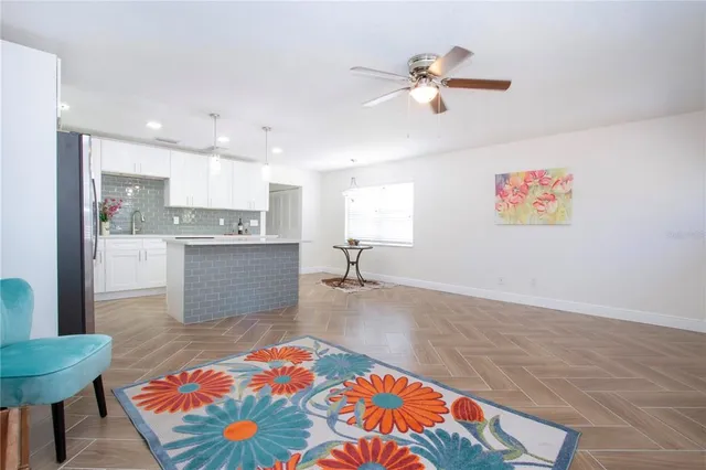 a kitchen with stainless steel appliances granite countertop a refrigerator a sink dishwasher a oven with white cabinets and wooden floor